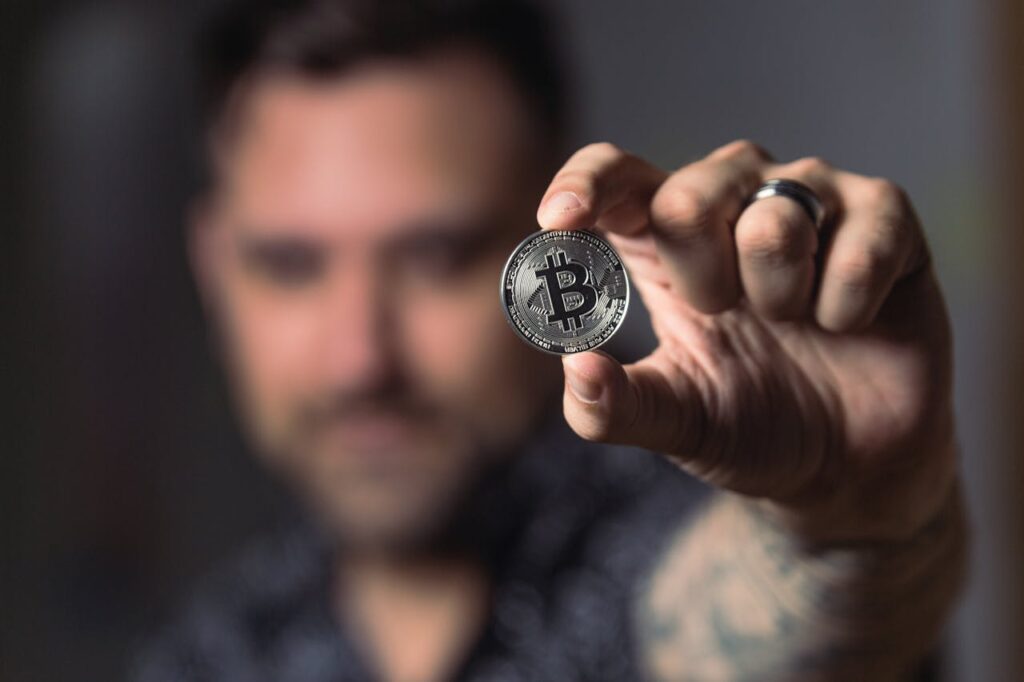 Man Holding Silver Bitcoin Coin