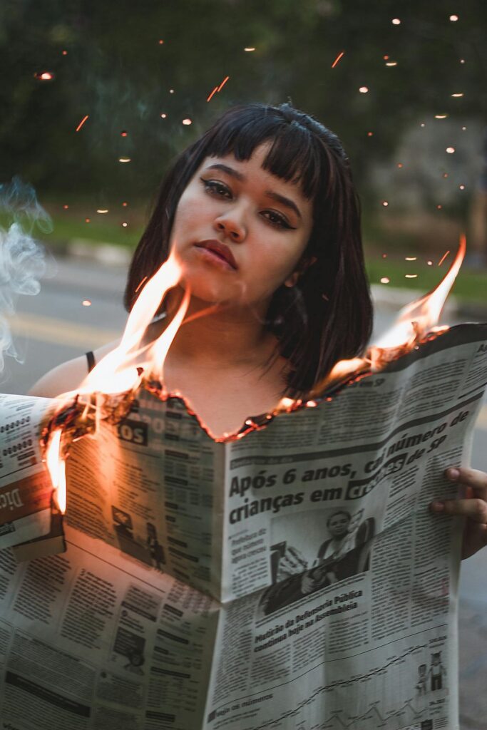Woman Holding Burning Newspaper
